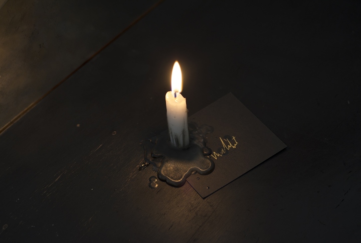 Свеча на фирменной табличке с логотипом