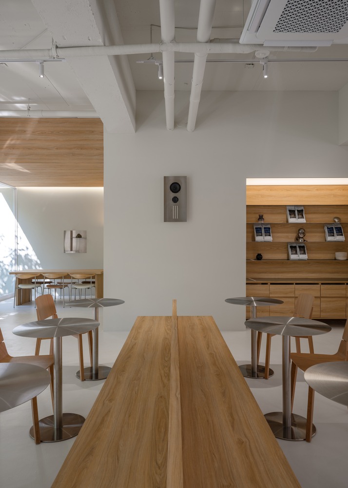 Длинный общий стол и минималистичный интерьер Prompt Café
