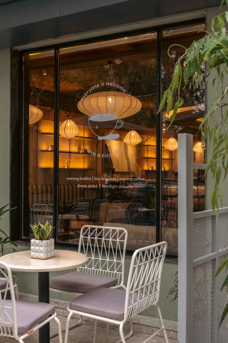 Фасад кафе с террасой и вечерним освещением Sidewalk Bakehouse and Cafe