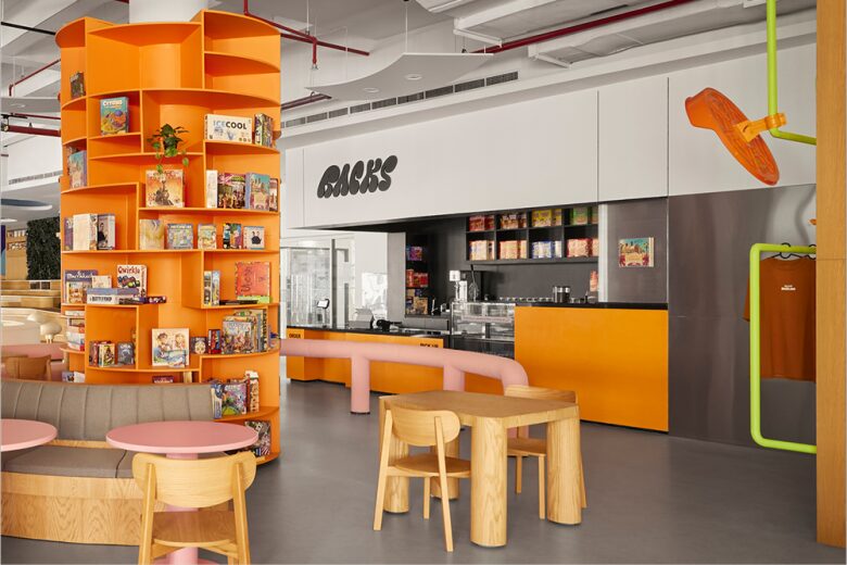 Интерьер кафе с ярким стеллажом и зоной посадки RACKS café