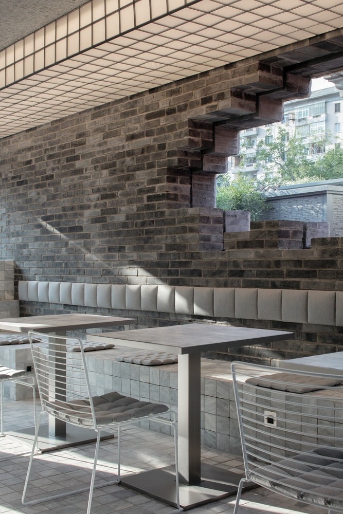 Кирпичная стена с оконным проемом и посадочными местами JM Café