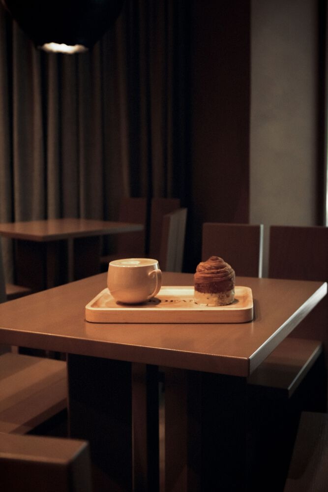 Кофе и десерт на столе в интерьере Kofan Coffee Shop