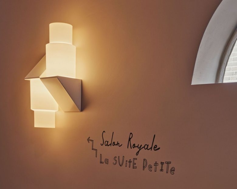 Настенный светильник и надпись Salon Royale в интерьере Hotel Rumour