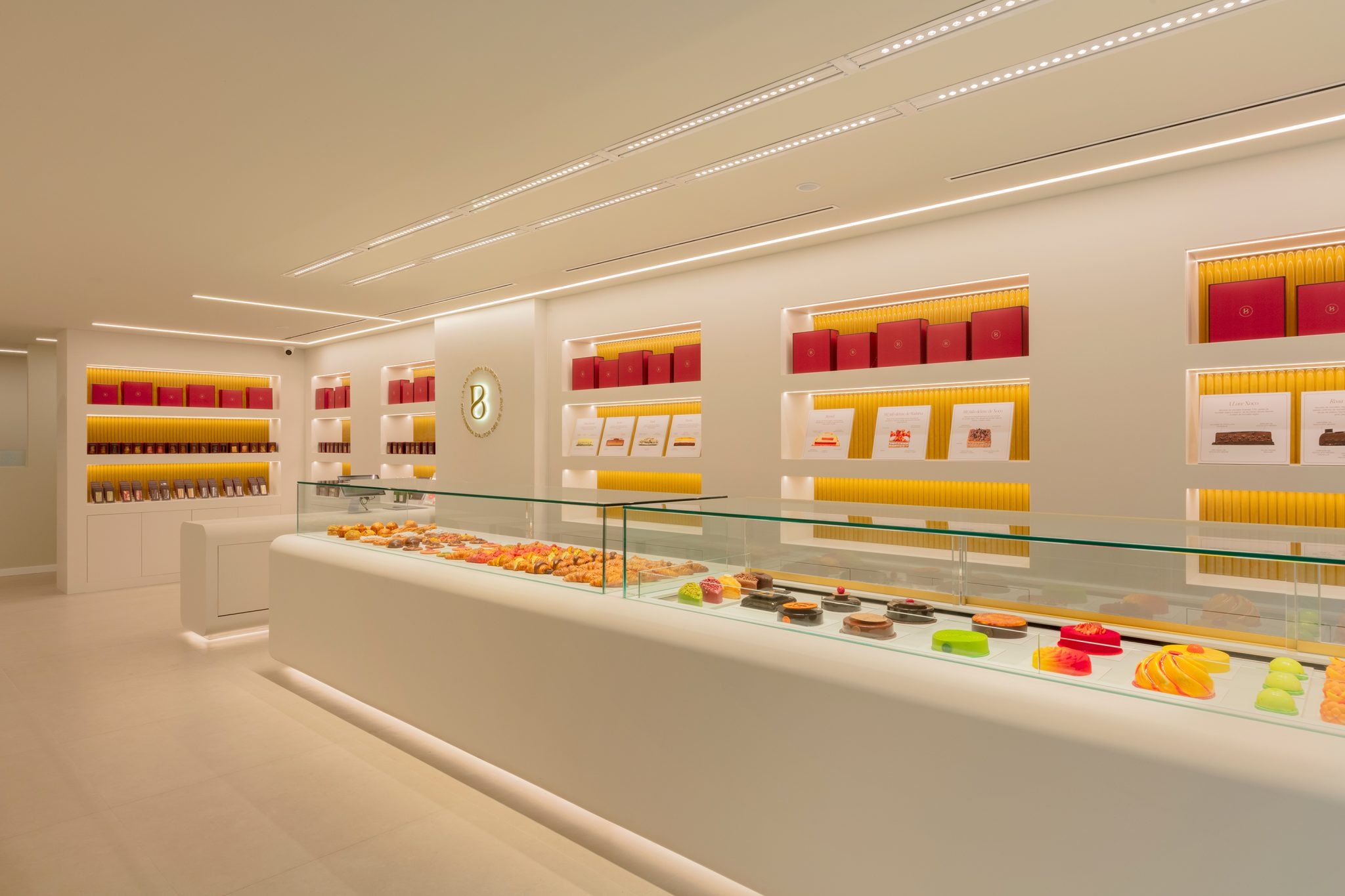 Общий вид интерьера с длинной витриной и ассортиментом La Pastisseria Barcelona