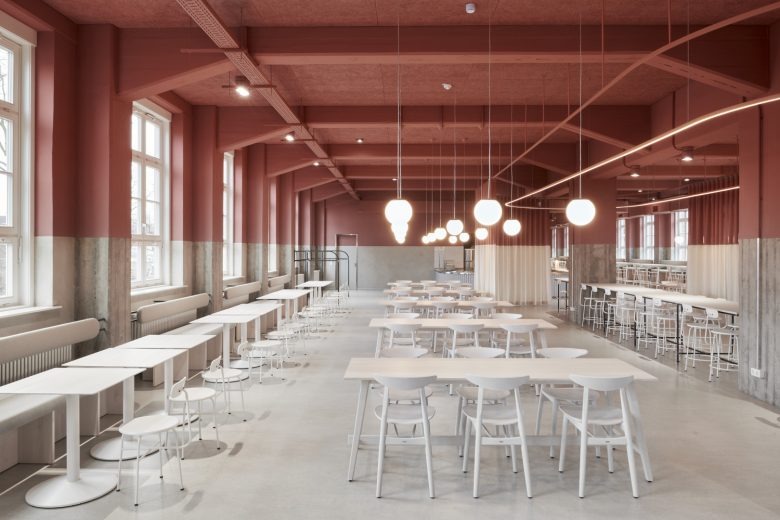Общий вид зала с подвесными светильниками и длинными рядами столов Hans & Werner