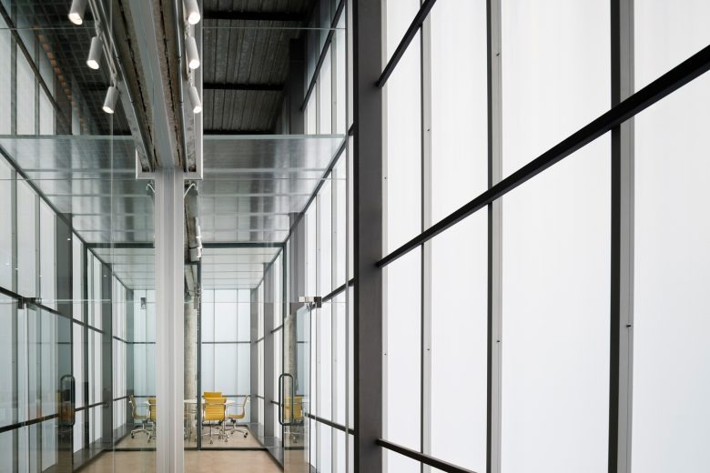 Переход к рабочей зоне с фасадными окнами Factory Coffee HQ