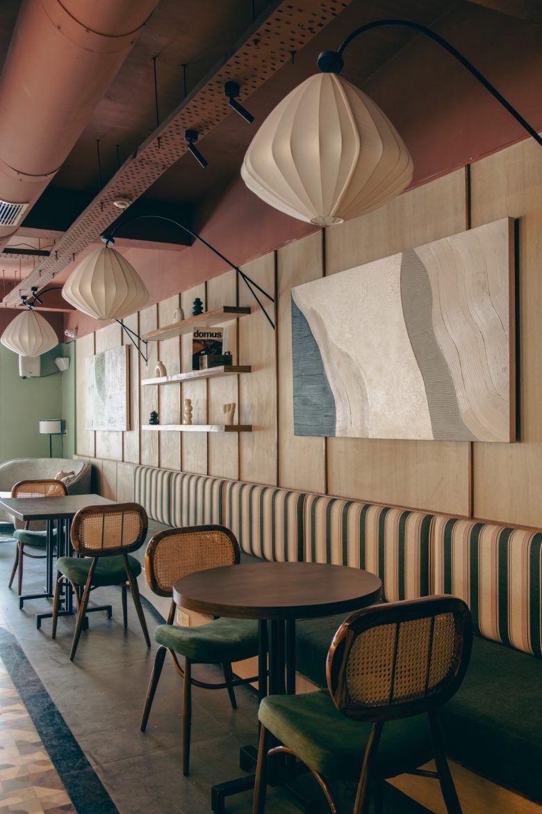 Ряд столиков с мягкими диванами и настенным декором Sidewalk Bakehouse and Cafe