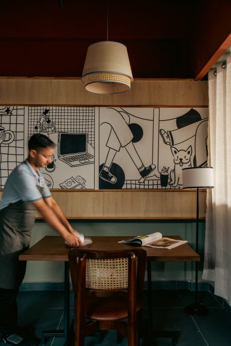 Стол с настенной графикой и сотрудником Sidewalk Bakehouse and Cafe