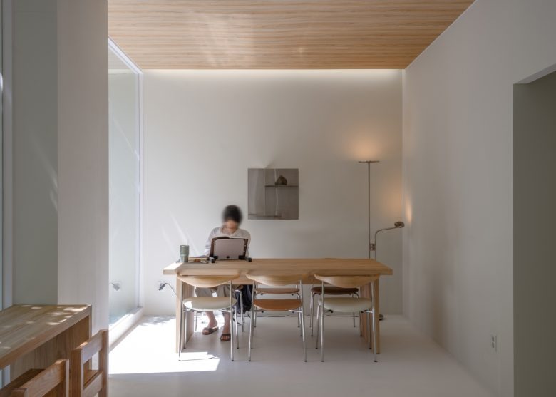 Уютная зона с длинным столом и посетителем Prompt Café