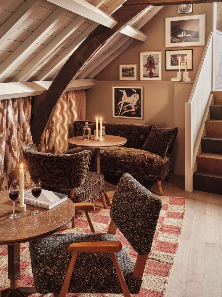 Уютная зона с креслами и столиком под скатной крышей Hotel Rumour