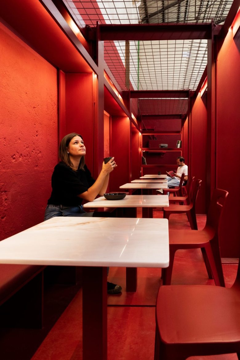 Узкий зал с красными столами Vibra Caffé + Concept Store