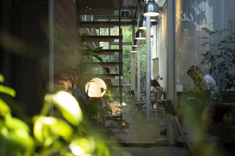 Вид через зелень на внутренний двор кафе Ton Corner Coffee Shop