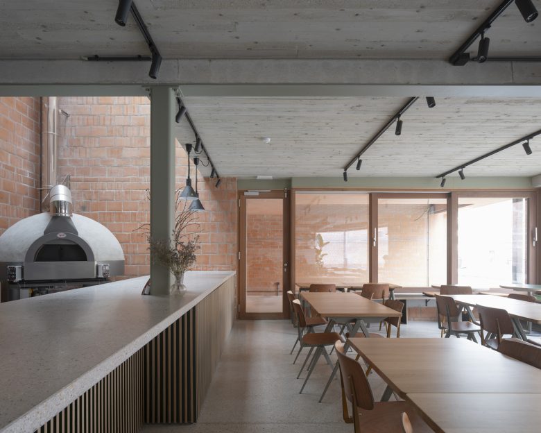 Зал кафе с деревянной мебелью и большими окнами Peper Multifunctional Building