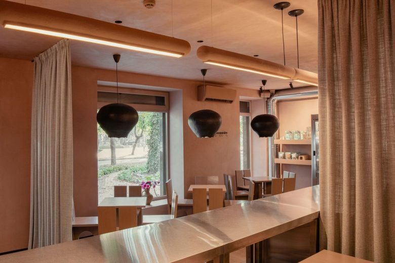 Зал кофейни с окнами и подвесными черными светильниками Kofan Coffee Shop