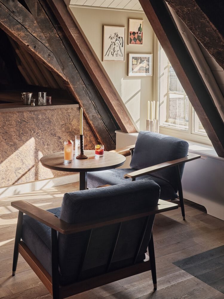 Зона отдыха с креслами у окна в мансарде Hotel Rumour