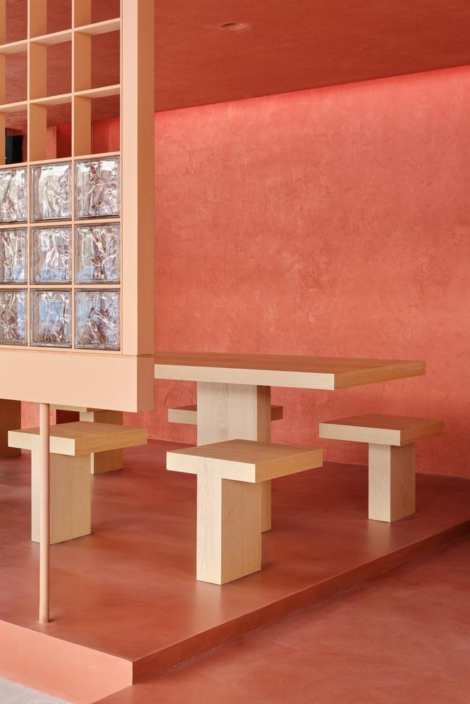 Зона посадки с деревянной мебелью и розовыми стенами Sijul Restaurant