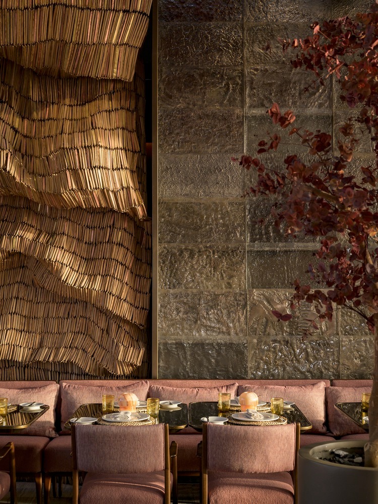 Зона со столиками и текстурной стеной Lucida Restaurant and Bar
