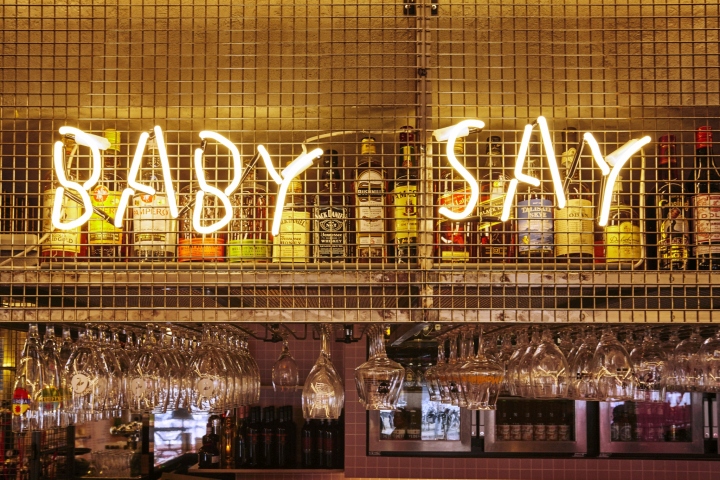 Светящаяся надпись над барной стойкой в дизайне бара