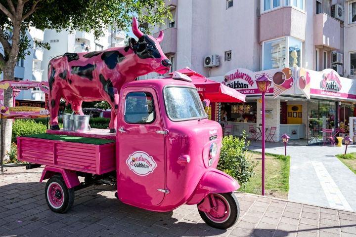 Ярко-розовая машина около кафе мороженого