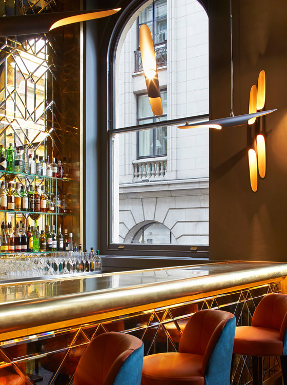 Золотистая отделка барной стойки в дизайне ресторана