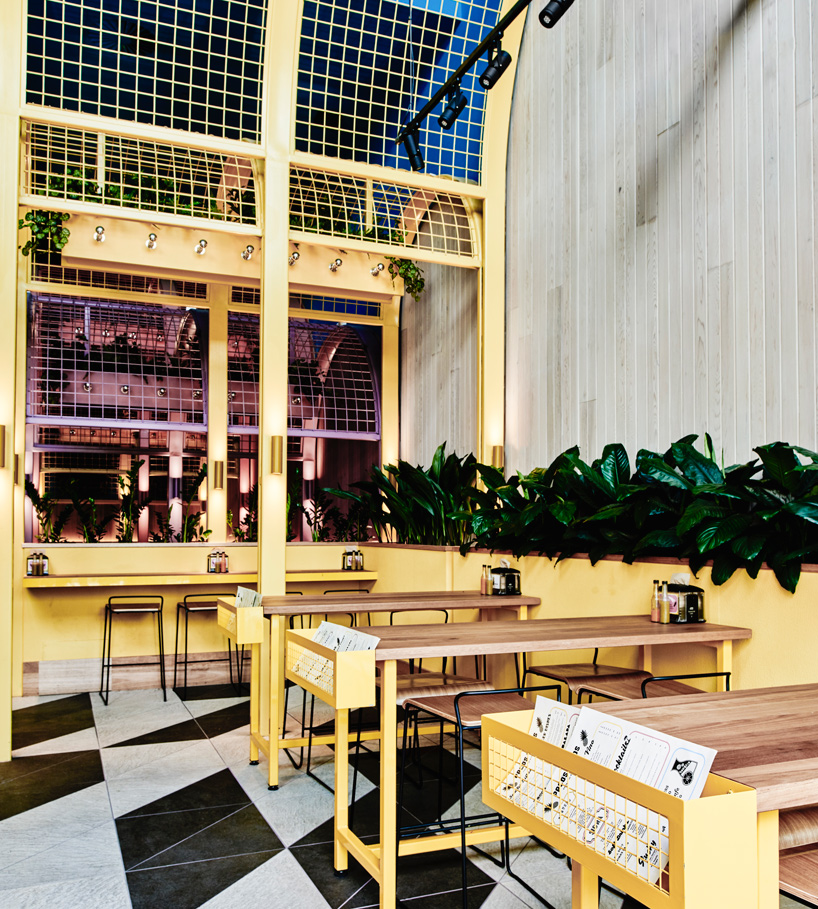 Интересный интерьер ресторана: деревянные столики с жёлтыми лоточками