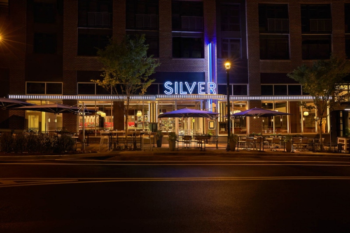 Яркая подсветка фасада бара-ресторана в вечернее время