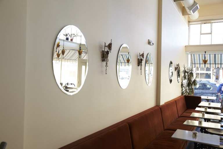 Круглые зеркала на стене в интерьере кафе в стиле ретро