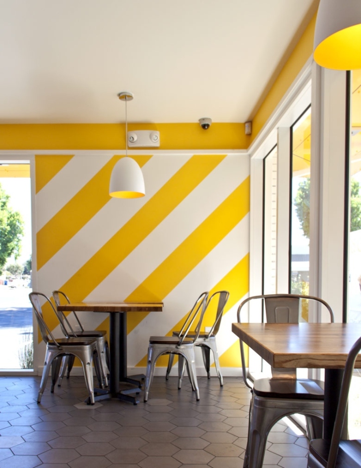 Жёлто-белые стены в интерьере кафе быстрого питания