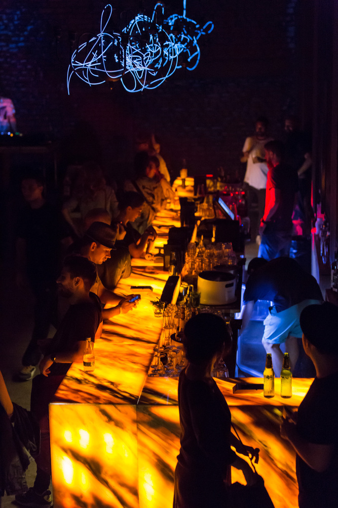 Ярка подсветка столешницы барной стойки в интерьере кафе клуба