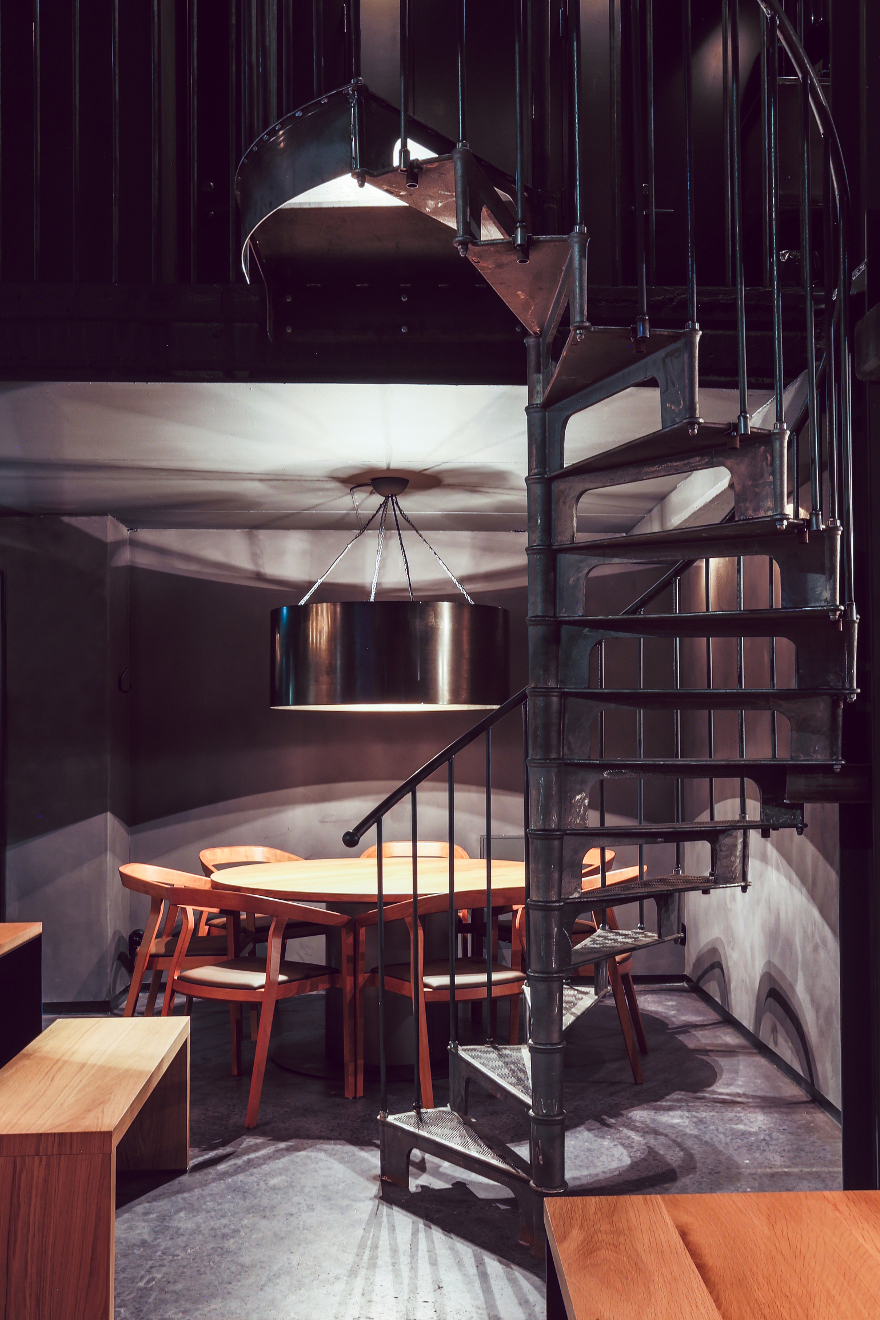Чёрная винтовая лестница в интерьере кафе в стиле лофт