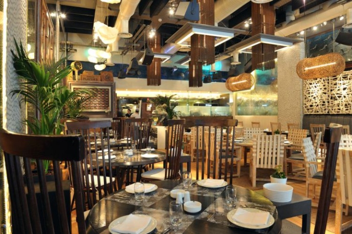 Тёмные деревянные столы в интерьере ресторана в морском стиле