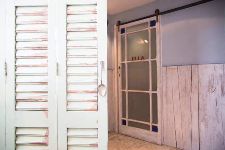 Белые двери туалета в винтажном стиле в оформлении пекарни