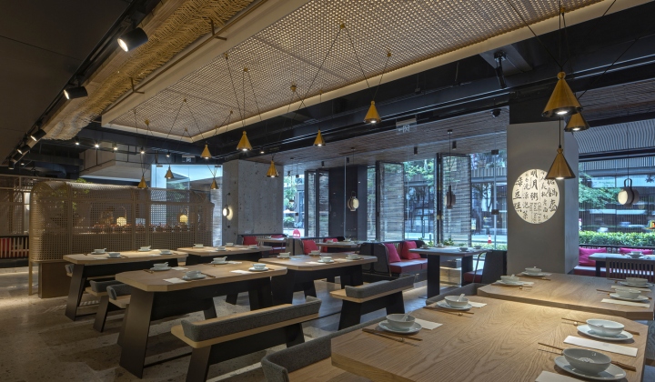 Светлые деревянные столы в ресторане с открытой кухней