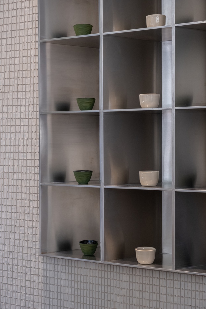 железные полки с чашками в стене Como Lounge Cafe